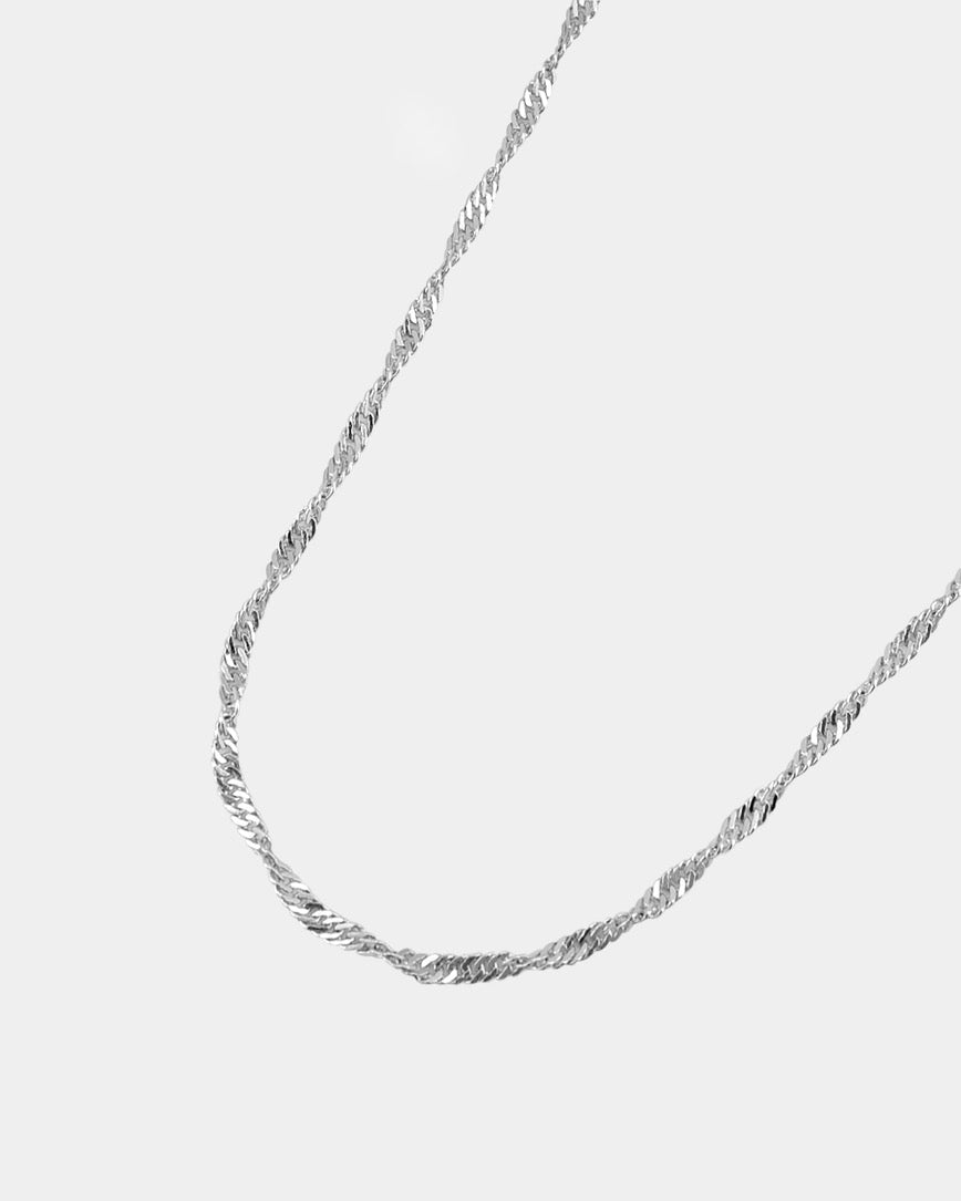Silver chain necklace on a light gray background