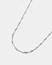 Silver chain necklace on a light gray background